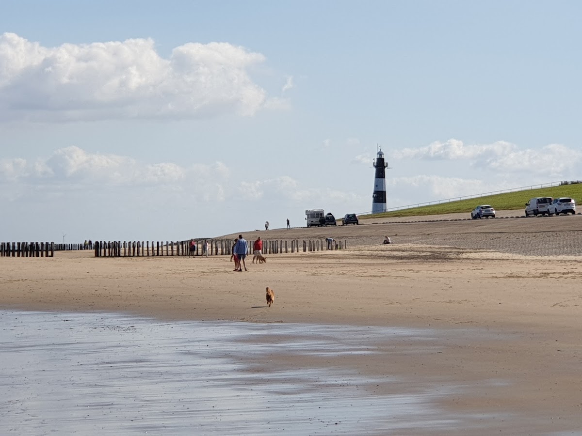 Breskens — Vuurtoren op strand met groene dijk