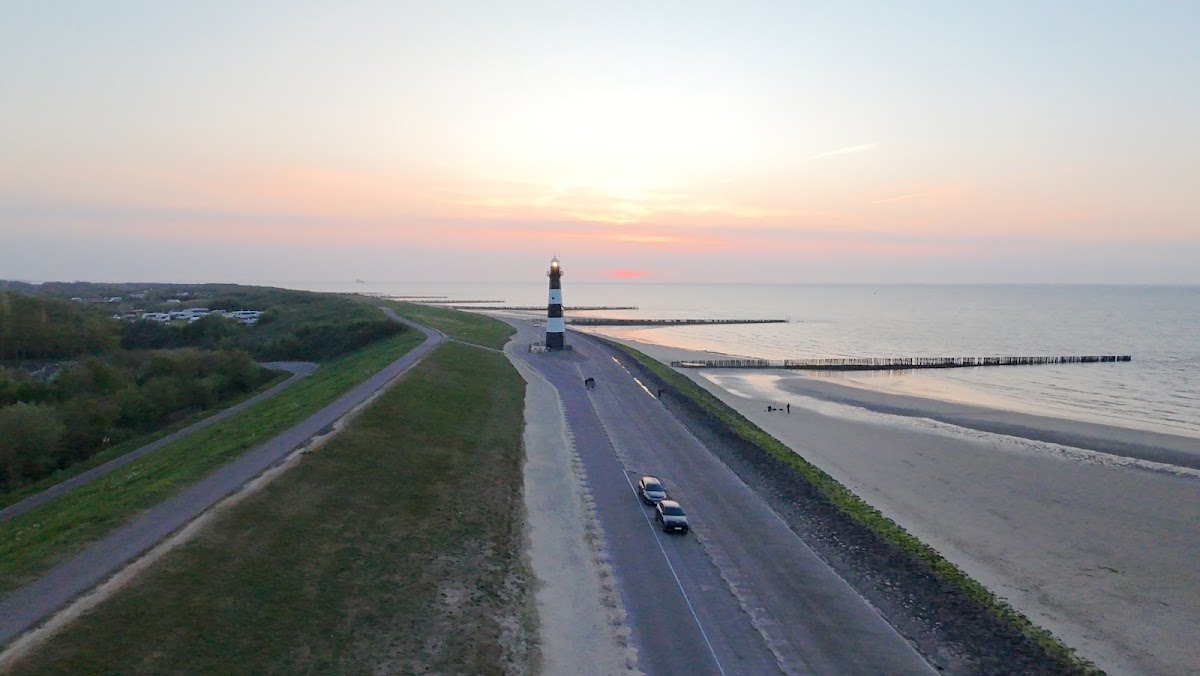 Breskens — Dijk met weg en vuurtoren bij zonsondergang