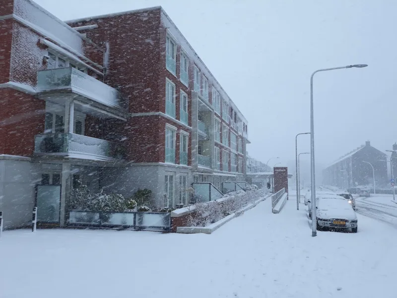 HEMA Wassenaar — Sneeuwweer bij bakstenen woongebouw buiten