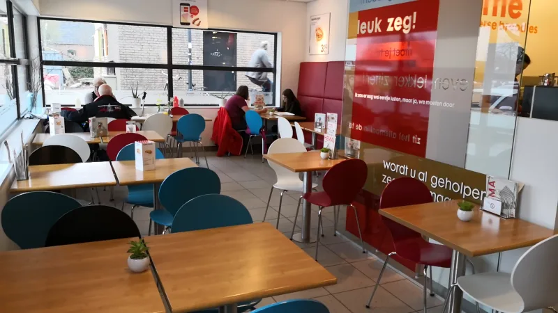 HEMA Wolvega — Winkelinterieur met zithoek en rood bord