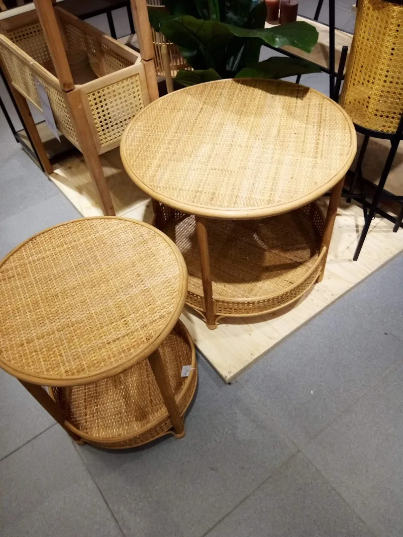 Xenos Leeuwarden — Ronde houten tafels met rieten stoelen